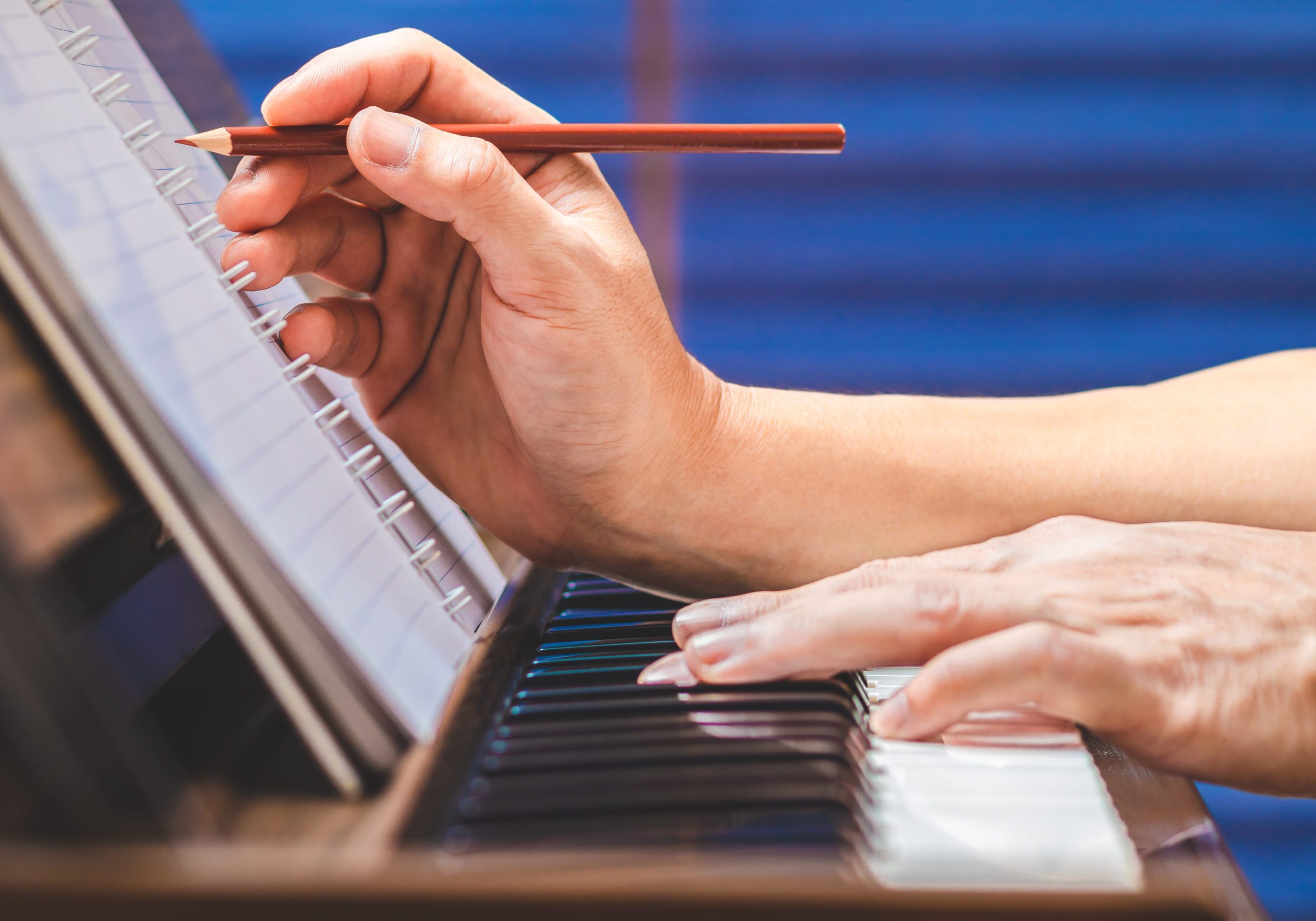A person is playing piano with a pencil